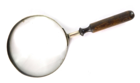 An early 20thC magnifying glass of large proportion, with turned handle, 33cm high.