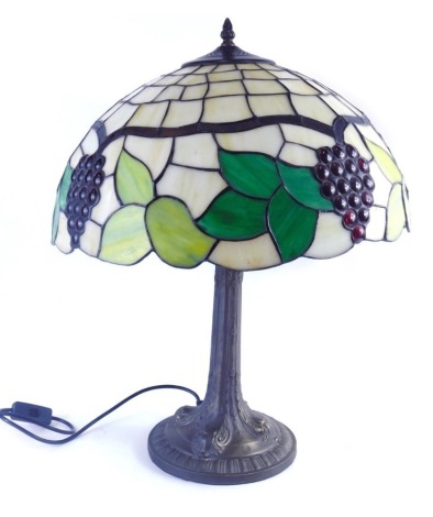 A Tiffany style table lamp, the glass shade set with leaves and berries, 43cm diameter.