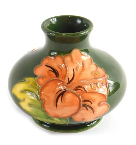 A Moorcroft Hibiscus pattern pottery vase, on green ground, impressed marks beneath, 9cm high.