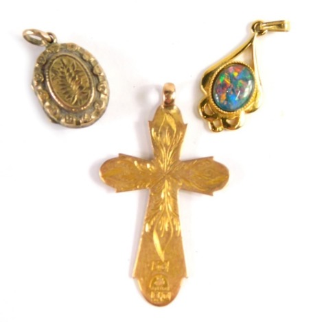 A group of 9ct gold and other jewellery, comprising a cross pendant with engraved initials LC, yellow metal numbered 56, unmarked, 2.7g, a Victorian gilt metal locket with fern decoration, 2cm high, and a silver and imitation opal pendant, 2cm high. (3)