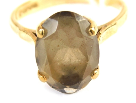 A 9ct gold smoky quartz dress ring, the oval smoky quartz in a raised basket setting with four claws, on V splayed shoulders, ring size P, 3.8g all in.