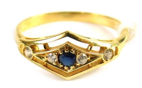 A sapphire and diamond dress ring, the shaped panel set with central sapphire, flanked by four tiny white stones, on a raised mount, yellow metal with rubbed hallmarks, ring size O½.