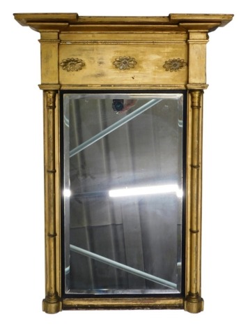 A 19thC giltwood inverted breakfront mirror, with bevelled glass flanked by cylindrical columns with floral patera, 93cm high, 72cm wide, 11cm deep.