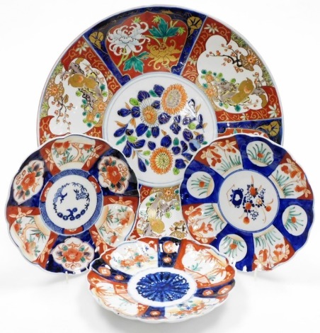 A 20thC Imari charger, decorated with reserves of birds and flowering shrubs, with a central floral medallion in traditional iron red, blue and gilt decoration, 39.5cm diameter, together with three Imari scalloped dishes, each 21cm diameter.