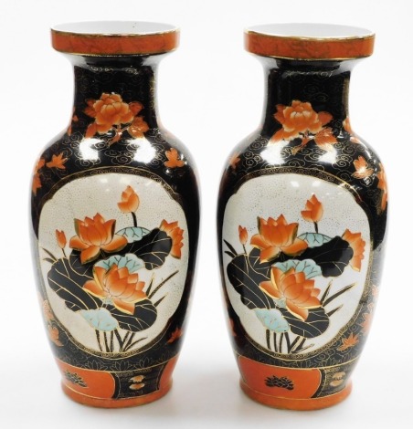 A pair of Chinese famille noir porcelain baluster vases, painted with floral designs in iron red, black and gilt, red seal mark to underside, 42cm high.