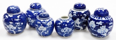 Six Chinese porcelain blue and white ginger jars, with prunus decoration, 14cm high, 11cm high, one lacking cover.