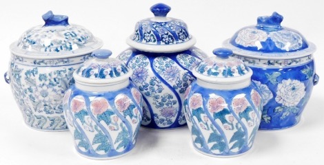 A pair of modern Chinese porcelain jars and covers, with hand painted floral decoration, 19cm high, together with a further two modern Chinese jars and covers with lion knop handles and hand painted with floral designs, 24cm high, and another 25cm high.