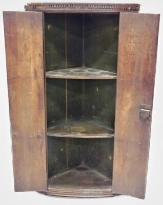 An early 19thC oak hanging corner cabinet, with carved dentil top above two plain doors revealing shelves, 102cm high, 55cm wide, 37cm deep. - 2