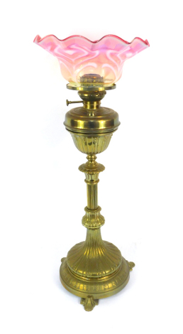 A Victorian brass standard oil lamp, with a frilled cranberry and opaline glass shade, 88cm high.