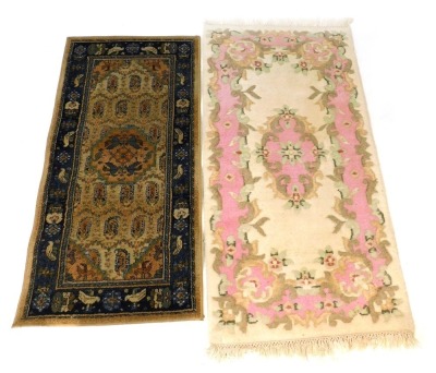 A Turkoman machine woven rug, decorated with a central lozenge, surrounded by a border decorated with flowers and animals, against a blue and cream ground, 68cm x 135cm, together with an Oriental style wool cut rug. (2)