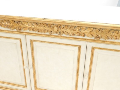 An associated suite of dining furniture, originally purchased for Harrods, comprising a continental cream and gilt painted side cabinet, the top with a moulded edge above a plain frieze applied with acanthus carving and three panelled doors each flanked b - 2