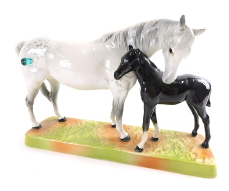 A Beswick pottery grey horse and black foal group, number 1811, impressed marks beneath, with label, 19cm high.