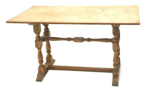 A 1920/30's oak refectory table, on twin part turned supports and H stretcher. 77cm high, 138cm wide, 76cm deep, and a matching sideboard with an arrangement of two drawers and two panelled doors, with hammered metal butterfly shaped hinges, on turned sup