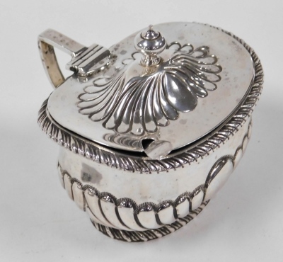 A Victorian silver mustard pot, of part fluted form with a gadrooned border and shaped finial, blue glass liner, Sheffield 1867, weighable silver 3.03oz, together with a salt spoon and a George V silver cigarette case, with engine turned decoration, Birmi - 2