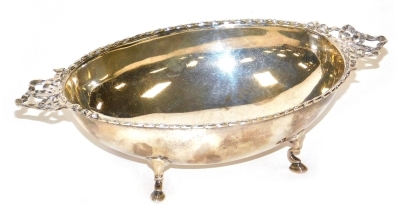 An Edward VII silver two handled dish, of oval form, with a raised border and pierced bow shaped handles, raised on four hoof feet, Birmingham 1907, 4.21oz, 18.5cm wide.