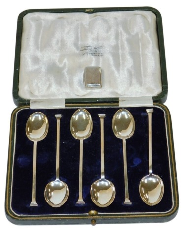 A set of six George V silver seal top coffee spoons, George Bishop and Sons, Sheffield 1923, 1.73oz, in fitted case, together with a William IV silver vinaigrette, with bright cut decoration, pierced grille lacking, Birmingham 1832, 2.5cm high.