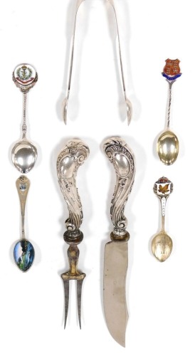 A group of small silver and white metal items, comprising a Continental white metal handled carving knife and fork, embossed with scrolls and flowers, marked 800, four commemorative enamel silver teaspoons, for Canada, Limerick, Pontresina and The Royal A