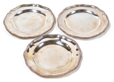 Three Edwardian silver dinner plates by R & S Garrard & Co, of Georgian design, with scalloped and gadrooned borders, numbers 1, 21 and 62 to reverse, 25cm diameter, London 1907, with maker's mark and stamped R&S Garrard & Co, Haymarket, London, 54oz.