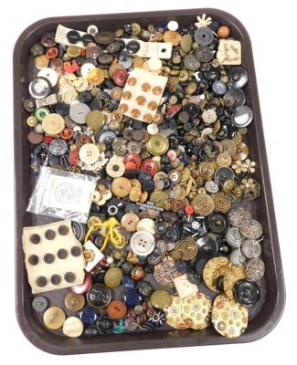 A collection of early 20thC and later buttons, varying designs and sizes, to include a set of six brass buttons embossed with coloured flowers, 4.5cm diameter, twisted circular brass buttons, embossed anchor buttons, some sets, etc. (1 tray)