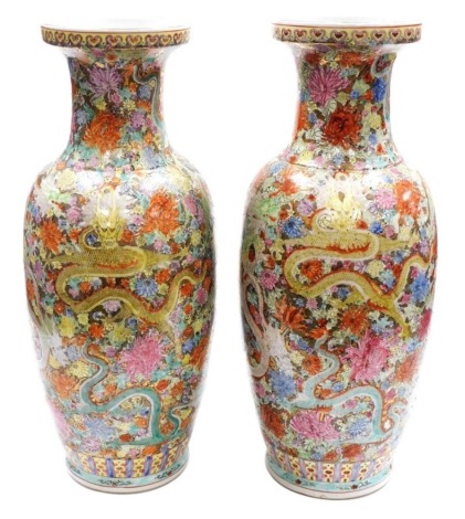 A pair of Jingdezhen famille rose porcelain vases, Chinese Republic or later, of shouldered ovoid form, painted with Imperial dragons and flowers against a gilt ground, six character mark, 60cm high. (AF)