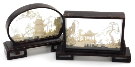 Two Chinese cork dioramas, each depicting buildings within landscapes, one in an oval hardwood frame, 21cm wide, the other in a rectangular hardwood frame 23cm wide.