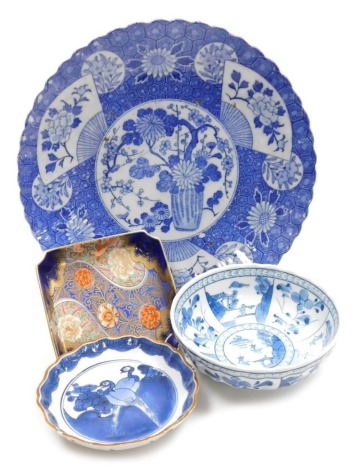 A Japanese blue and white bowl, 16.5cm diameter, together with a Japanese blue and white dish painted with pheasants, a Japanese blue and white charger, and a Japanese Fukugawa shallow dish with Imari decoration.