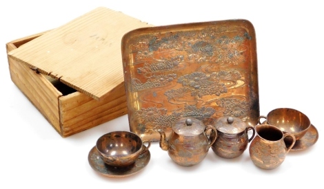 A Japanese Meiji period soft metal coffee set, comprising tea pot, jug and sugar bowl with a pair of cups and saucers, matching tray, decorated in low relief with chrysanthemums, the tray 17cm x 15cm, in a wooden box.