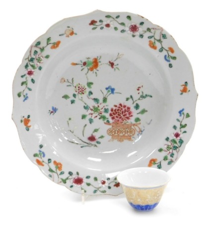 An 18thC Chinese porcelain famille rose dish, decorated with floral sprigs, 23cm diameter (AF), together with a porcelain tea bowl in blue and gilt with six character Chenghua mark, 4cm high.