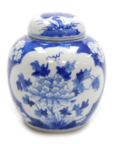 A Chinese blue and white ginger jar and cover, hand painted with reserves of peonies, against a cracked ice ground, 15cm high.