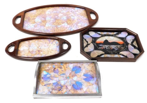 Four early 20thC vintage trays, butterfly wing decorated, comprising a pair of graduated mahogany framed twin handled trays, 69cm and 44cm wide, an octagonal oak framed tray, decorated with a view of Rio within a surround of butterflies, 42cm wide, and a 