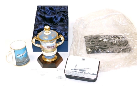 An Aynsley porcelain twin handled cup and cover, to commemorate twenty five years of passenger flight of Concorde 1976-2001, painted with reserves of Taking Off, and Over New York City, limited edition no. 35/100, painted by J Shaw, boxed with stand and c