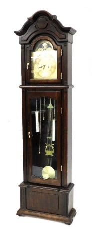 A Lincoln thirty one day oak cased longcase clock, the break arch dial with moon phase, engraved dial with chapter ring bearing Arabic numerals, three train movement, the case with shaped pediment, and glazed door, raised on a stepped base and block feet,