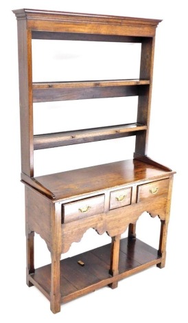 A late 20thC oak dresser, the top with a moulded cornice above two plate racks with iron hooks, the base with three drawers with brass handles above a pot board base, on stiles, 174cm high, 98cm wide, 39cm deep.