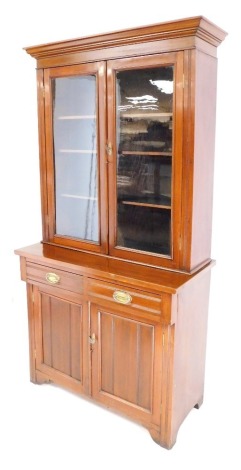 A Victorian mahogany cupboard bookcase, the top with a moulded cornice above two glazed doors enclosing an arrangement of shelves, the base with two drawers above two panelled cupboards, on bracket feet, 210cm high, 108cm wide, 50cm deep. (AF)