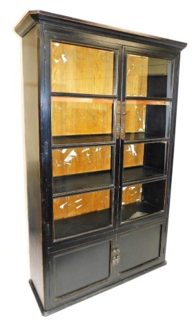 A Shanxi Chinese ebonised hardwood cabinet, the top with a moulded edge above two glazed panelled doors enclosing three shelves, the base with two cupboard doors on a shaped plinth base, with pierced metal mounts and handles, 206cm high, 120cm wide, 40cm 