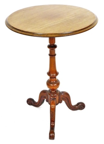 An early 19thC mahogany occasional table, the circular top raised on a turned column, above three carved scroll cabriole legs, 74cm high, the top 52cm diameter.