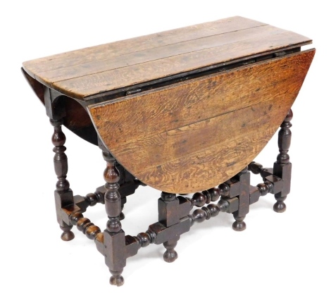 An 18thC oak gate leg table, the oval top on part turned supports, with pad feet, 73cm high, 102cm wide.