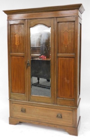 An Edwardian mahogany and inlaid double wardrobe, the outswept pediment over a single door, inset bevelled glass, enclosing a hanging rail, over one long frieze drawer, raised on bracket feet, 198.5cm high, 130cm wide, 49cm deep.