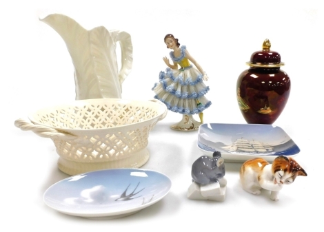 A group of porcelain, to include a Royal Worcester cream porcelain jug, of moulded leaf form, printed marks, 17cm high, a Carltonware Rouge Royale Mikado ginger jar and cover, 14cm high, a Royal Doulton model of a cat, Royal Copenhagen wares, crinoline f