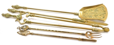 A brass three piece fireside companion set, comprising shovel, tongs and a poker, together with a further toasting fork and poker.