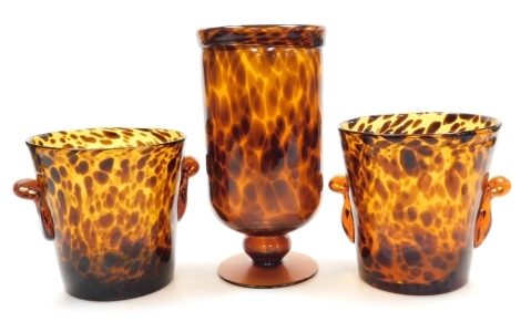 A Two's Company tortoiseshell glass vase, of cylindrical form on a circular base, 27cm high, together with a pair of similar vases or two handled wine coolers, 16cm high.