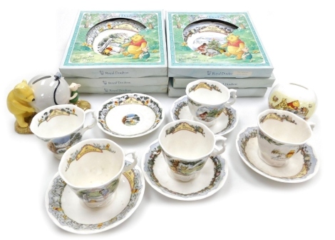 A group of Royal Doulton Winnie The Pooh Collection china, comprising five teacups and saucers, six cabinet plates, and two money boxes, all boxed.