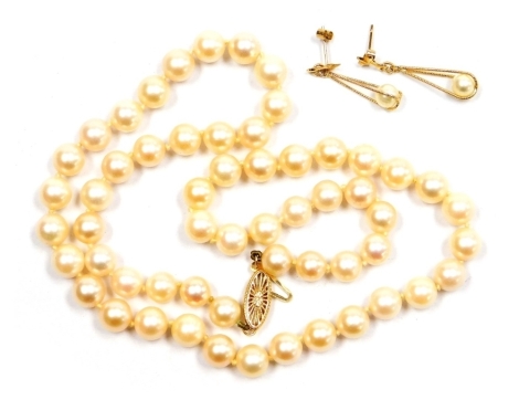 A string of cultured pearls, of uniform size, on a clasp stamped 14k, together with a pair of 9ct gold and cultured pearl drop earrings.