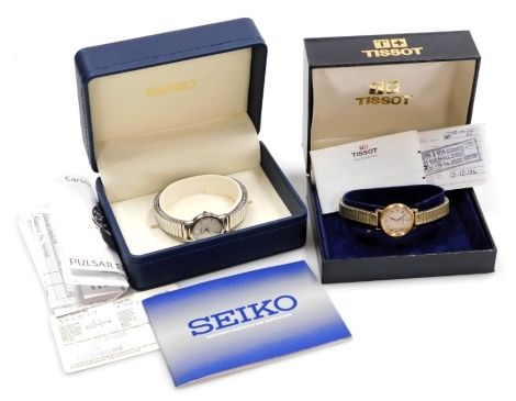 A Tissot lady's gold plated wristwatch, the circular silvered dial with engine turned decoration, Arabic numerals, on a plated strap, boxed, together with a Seiko lady's stainless steel cased wristwatch, boxed. (2)