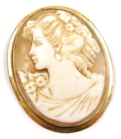 A 9ct gold and shell cameo brooch, bust portrait of a lady with floral corsage, 42mm high x 37mm wide.