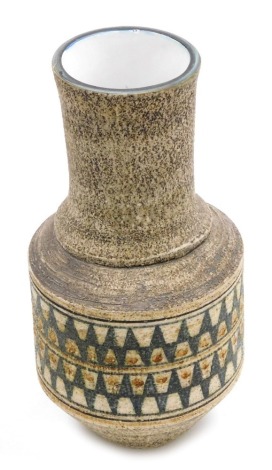 A Troika pottery vase, of cylindrical shouldered form with an elongated neck, the body decorated with bands of green and brown painted circles and triangles against a mottled texturised brown ground, signed to underside, 26cm high.