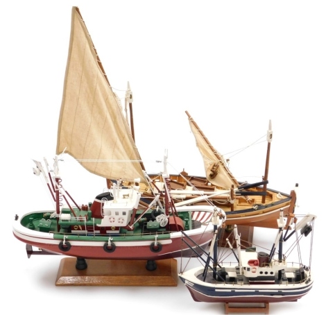 Three model boats, comprising a trawler boat, 24cm high, sailing yacht, 50cm high overall, and a further trawler.