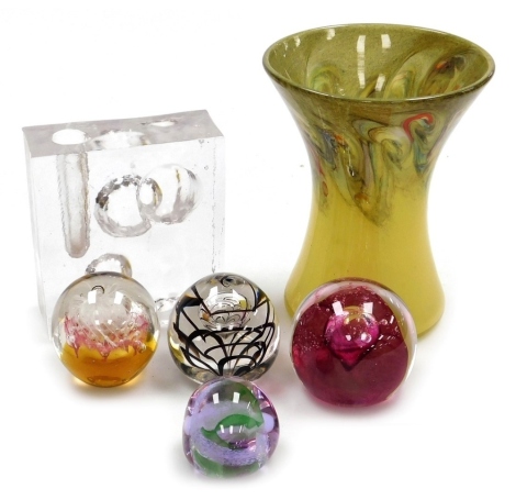 A group of glassware, to include a Strathearn glass vase, of waisted form, decorated with multiple swirls against a yellow ground, seal mark beneath, 19cm high, four paperweights including two Caithness weights decorated in the Fireball and Pebble pattern