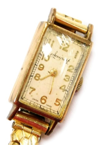 An Accurist 9ct gold cased lady's wristwatch, rectangular champagne dial bearing Arabic numerals, on a plated strap.