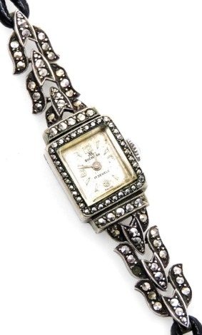 A mid century Bucherer stainless steel cased cocktail watch, rectangular silvered dial bearing Arabic numerals at quarters, the case set with marcasites, on a part marcasite set and leather strap.